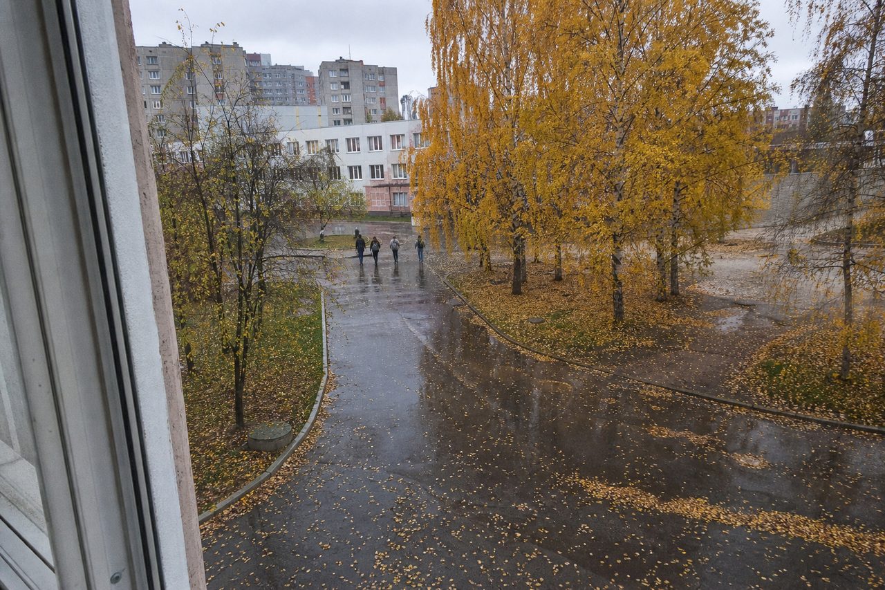 Школьный двор в начале октября, вдали уходят ученики с рюкзаками