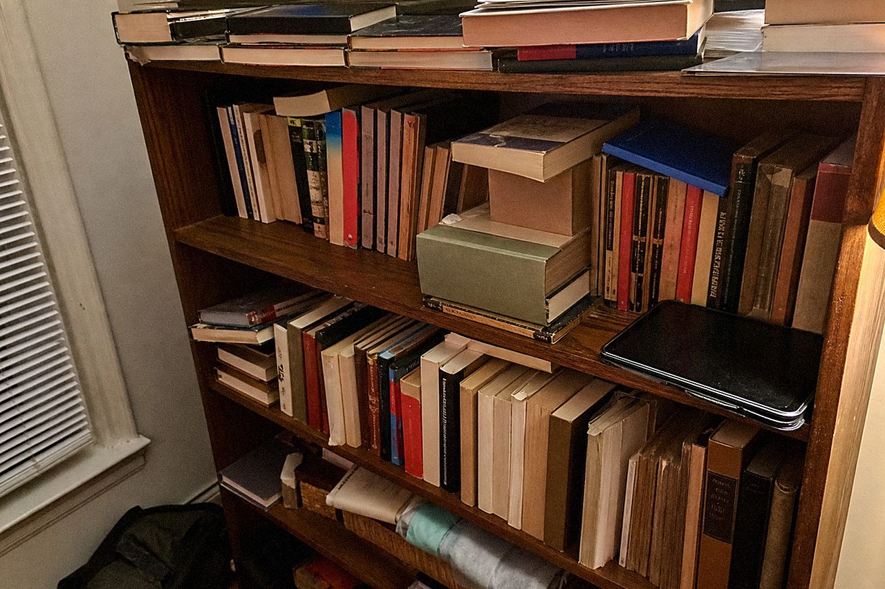 Книжная полка с зачитанными книгами и выключенным планшетом на краю