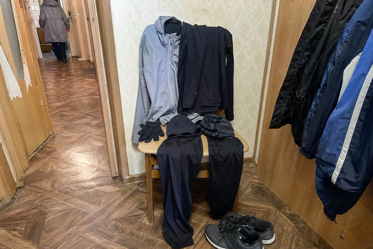 Беговая одежда сложена на деревянном стуле в прихожей: термокофта, ветровка, тайтсы, перчатки, шапка и шарф-труба, рядом на полу кроссовки
